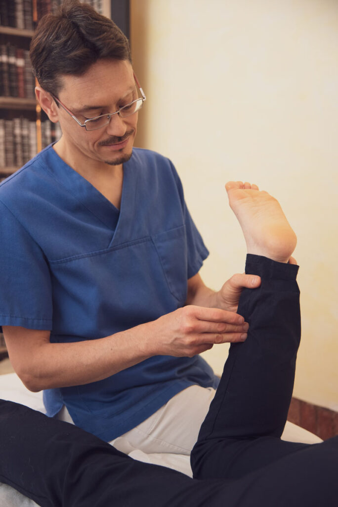 Il dottor Stefano Borzone applica una tecnica di osteopatia ad un paziente nel suo studio di Genova.