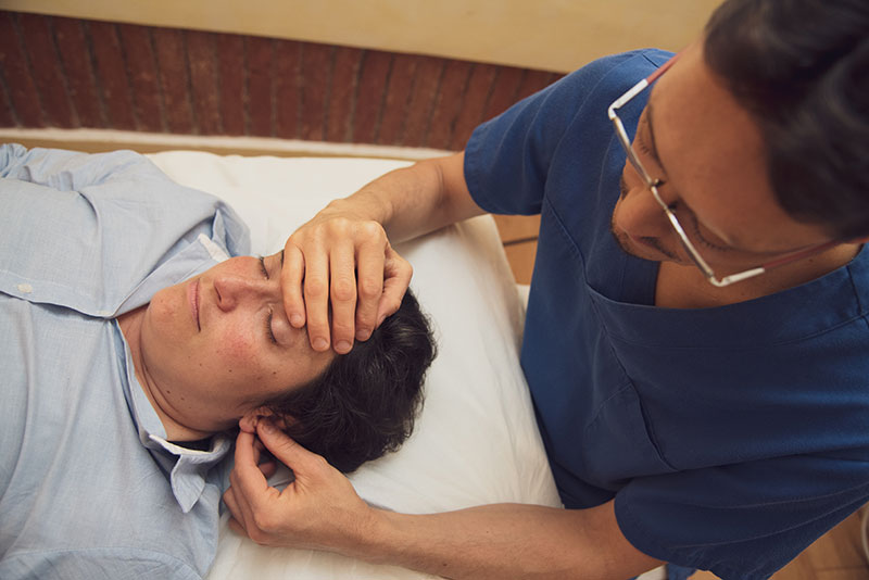Il dottor Stefano Borzone, osteopata di Genova, sta curando un paziente.